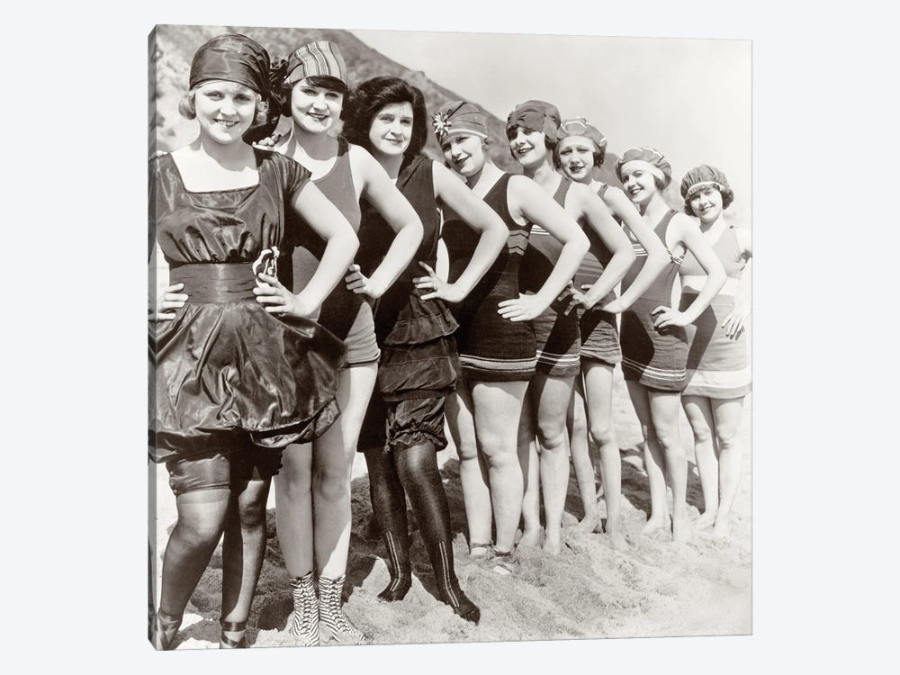 1920s Group Of Smiling Women Wearing One Piece Bathing Suits And Caps Posing Lined Up On Beach Looking At Camera by Vintage Images 1-piece Canvas Artwork