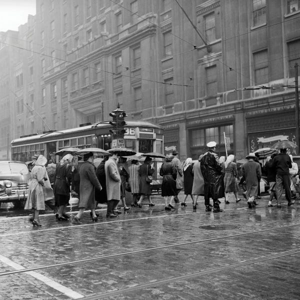 1940s 1950s Pedestrian Intersection City Cross Walk Umbrellas Rain Wet Weather Trolley Car Philadelphia Pennsylvania USA