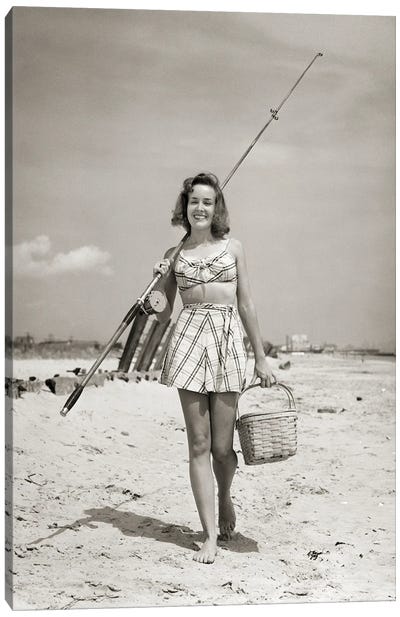 1940s Smiling Young Woman Walking On Beach Looking At Camera Wearing Two Piece Bathing Suit Skirt Carrying Surf Fishing Gear Canvas Art Print - Vintage Images