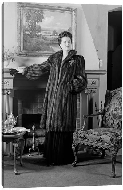 1940s Woman In Formal Living Room Standing In Front Of Fireplace Wearing Full-Length Fur Looking At Camera Canvas Art Print - Vintage Images