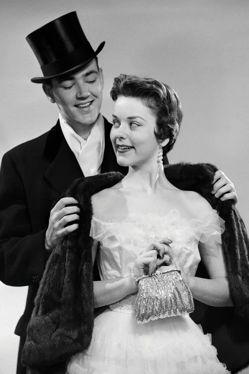 1950s Couple Formal Attire Man Wearing Top Hat Helping Woman In Evening Clothes With Fur Stole