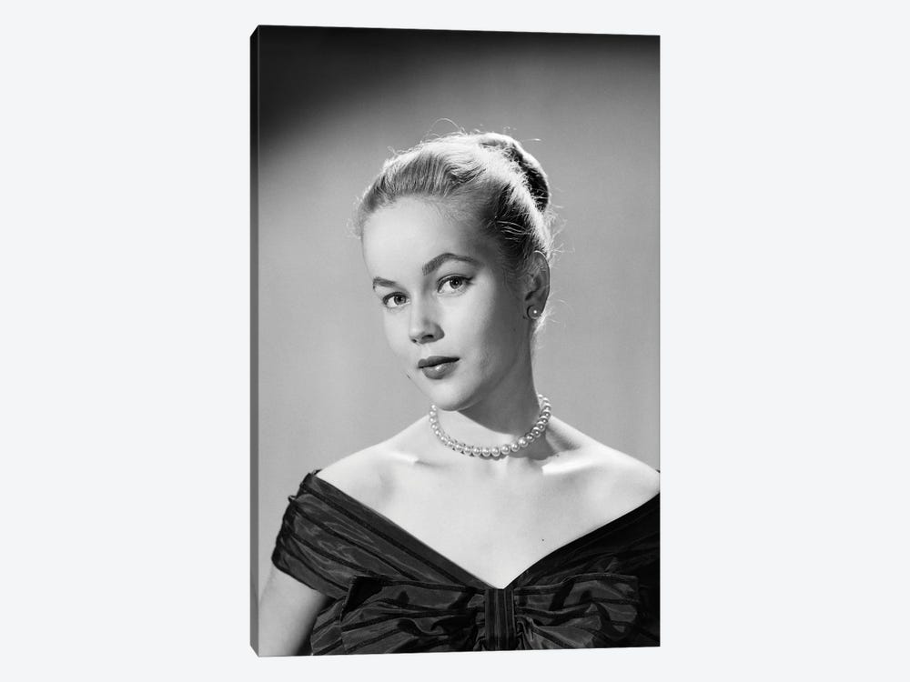 1950s Portrait Young Blond Woman Serious Facial Expression Pearl Necklace Black Satin V Neckline Evening Dress Looking At Camera by Vintage Images 1-piece Canvas Artwork
