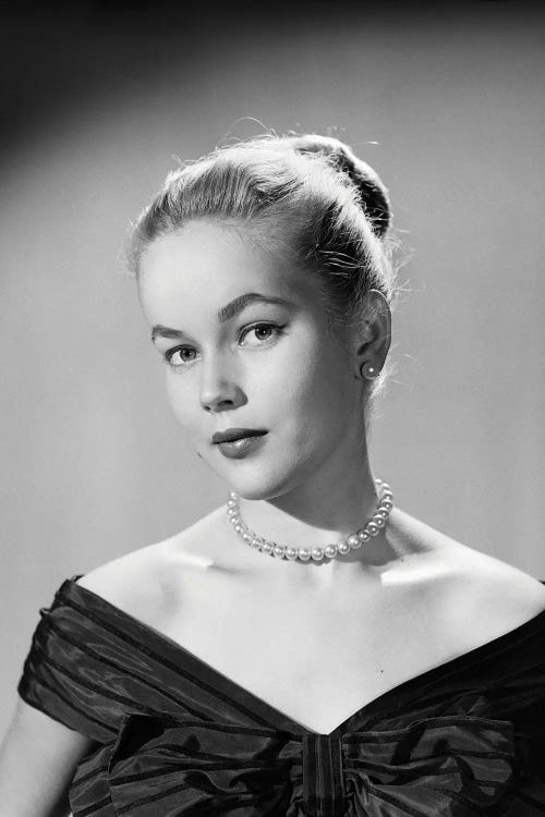 1950s Portrait Young Blond Woman Serious Facial Expression Pearl Necklace Black Satin V Neckline Evening Dress Looking At Camera