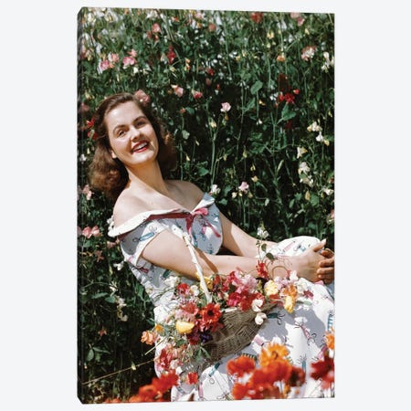 1950s Smiling Woman Sitting In Meadow Holding Basket Of Flowers Looking At Camera Canvas Print #VTG805} by Vintage Images Canvas Print