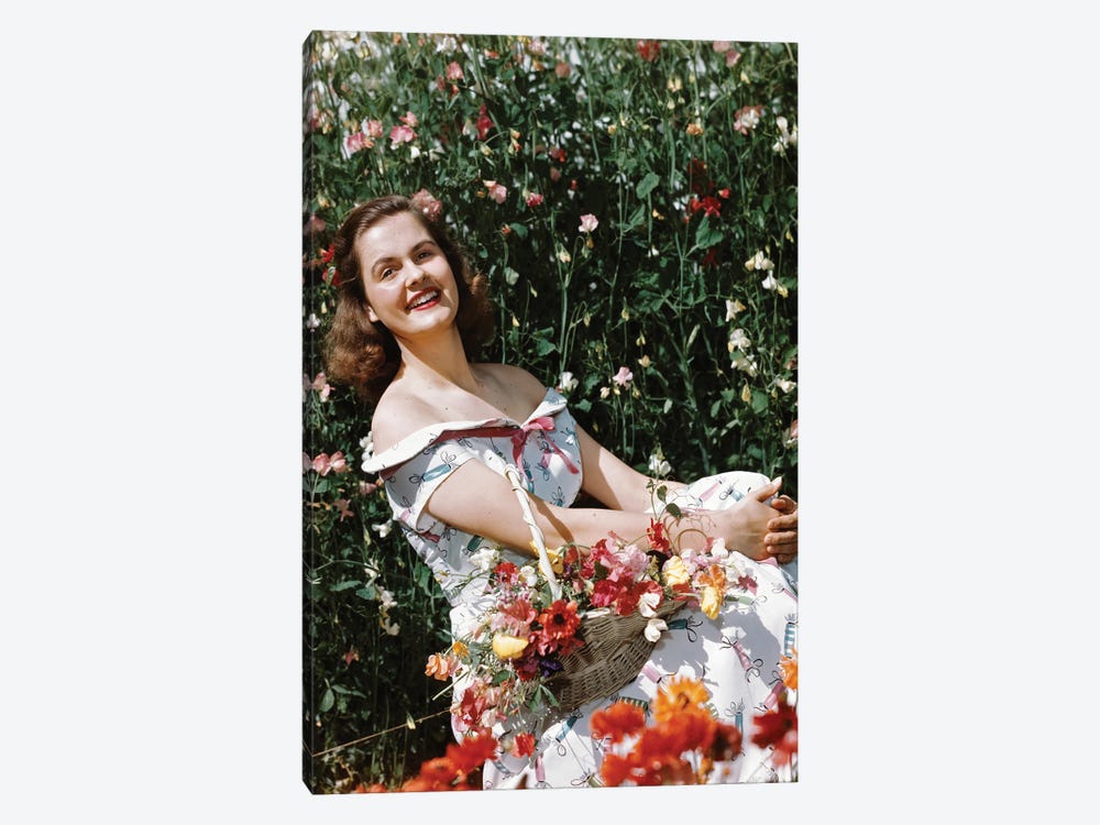 1950s Smiling Woman Sitting In Meadow Holding Basket Of Flowers Looking At Camera by Vintage Images 1-piece Canvas Wall Art