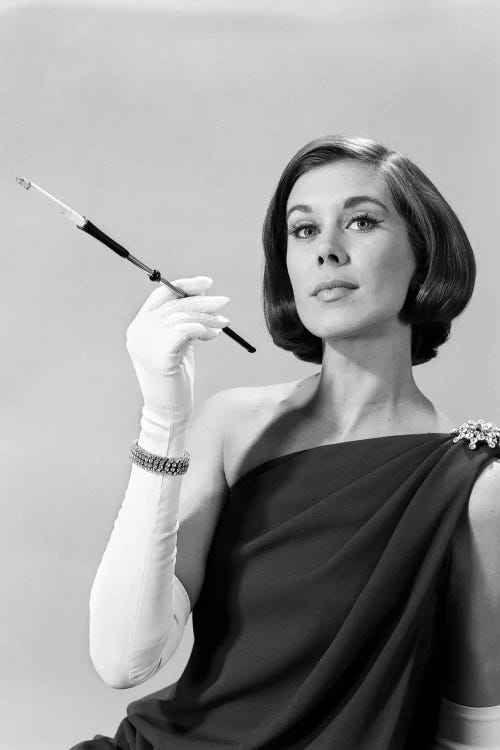 1960s Formally Elegantly Dressed Young Woman Arrogant Expression Holding Long Cigarette Holder Wearing Long White Gloves