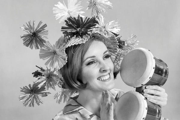 Historical Fashion: 1960s Smiling Woman Wearing Goofy Straw Hat Playing Bongo Drums by Vintage Images