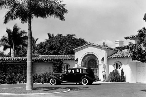 Miami: 1930s Car In Circular Driveway Of Tropical Stucco Spanish Style Home In Sunset Islands Miami Beach Florida USA by Vintage Images