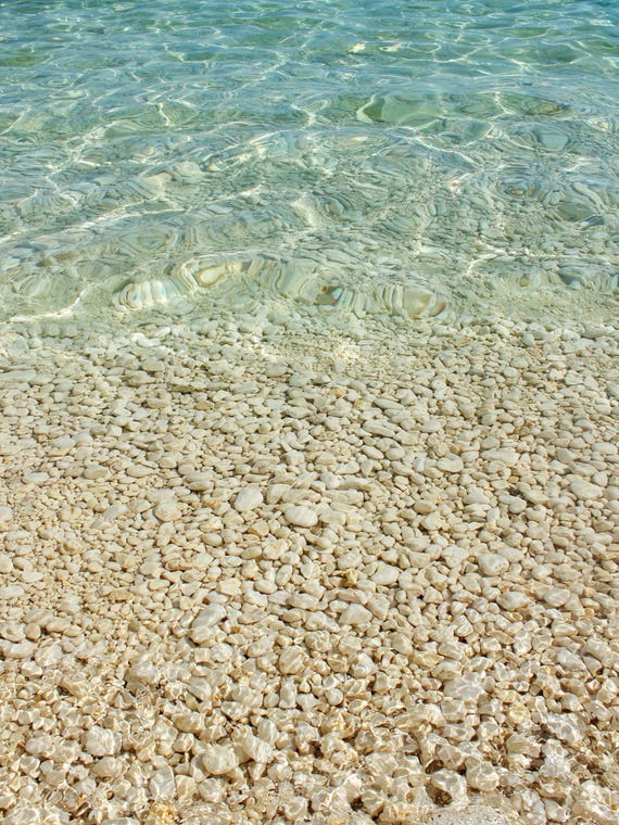 Aqua Blue Ocean And Golden Pebbles by Alyson Fennell